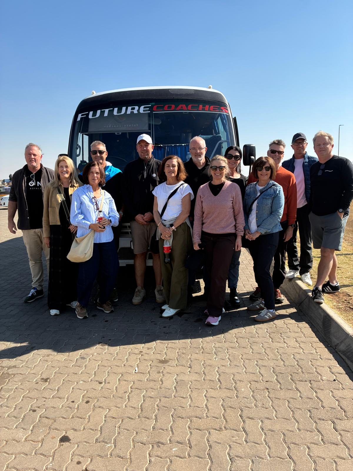 Group of travelers in front of their tour coach