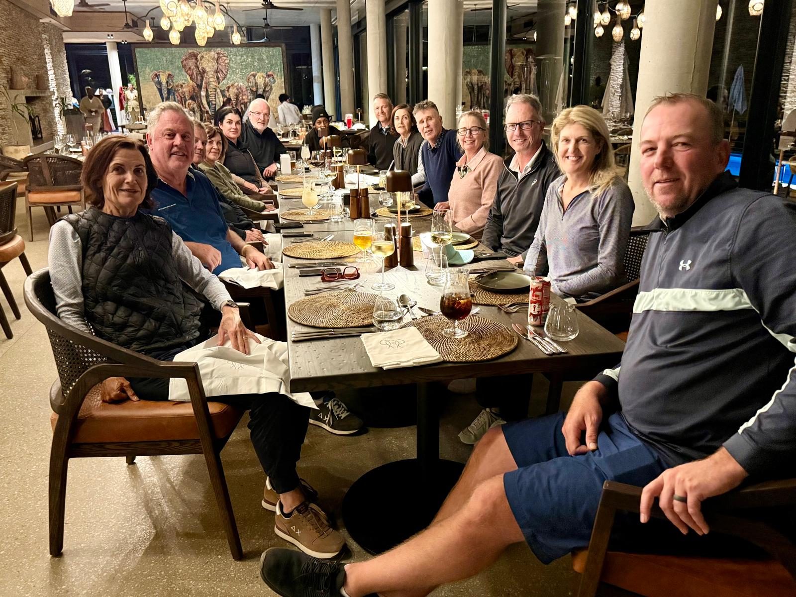 Group seated at a long dinner table outdoors
