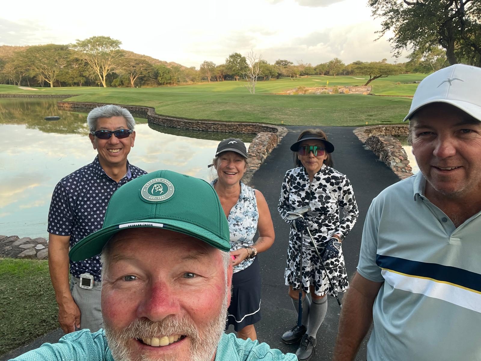Group of golfers on the course beside a lake